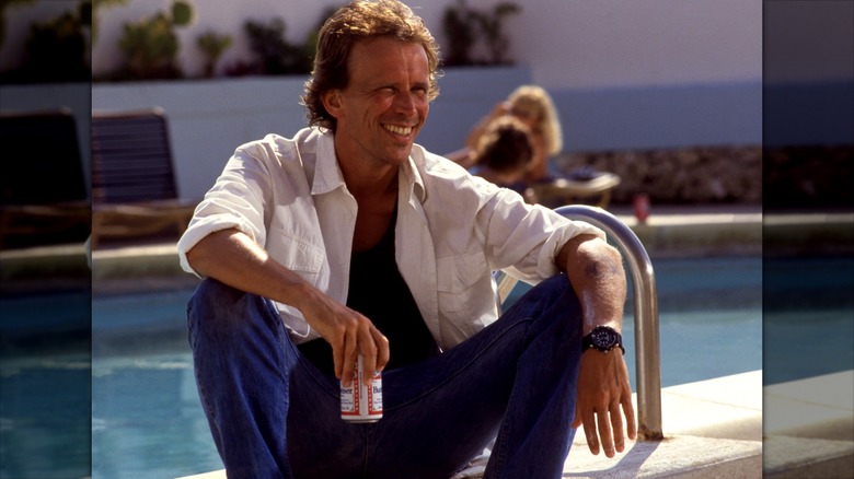 Peter Weller smiles with a Budweiser in hand
