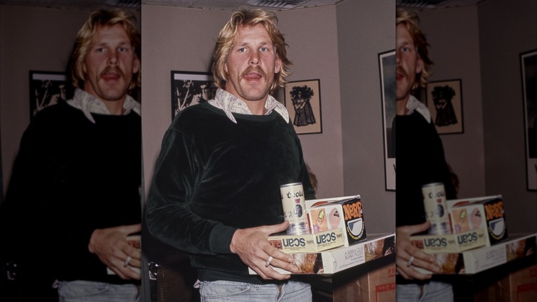 Nick Nolte carrying a Coors Banquet and a pile of other things