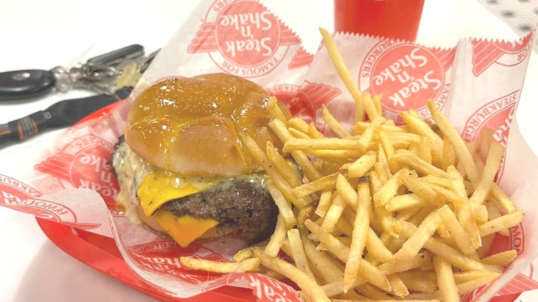 A buttery Steak 'n Shake cheeseburger and fries on a red tray.