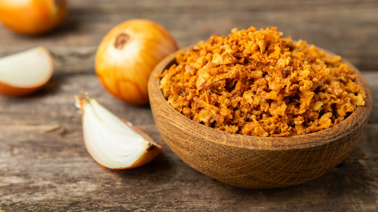 Crispy fried onions in a bowl on a wooden table