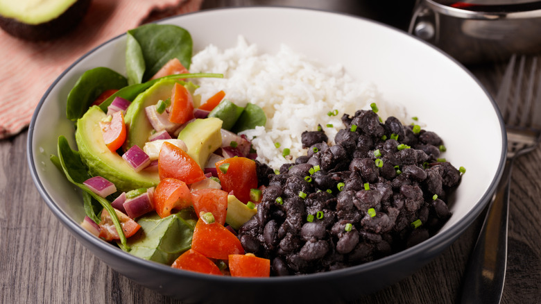 A hearty vegetarian meal of white rice, black beans, and salad