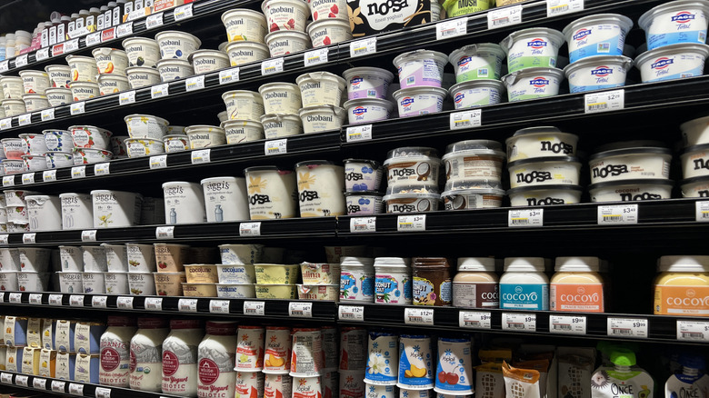 Supermarket shelf stocked with various yogurt brands