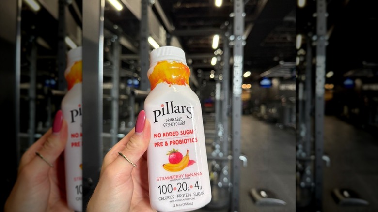 Hand holding a Pillars Strawberry Banana bottle