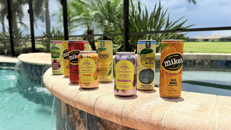 Cans of boozy lemonades by the pool outside