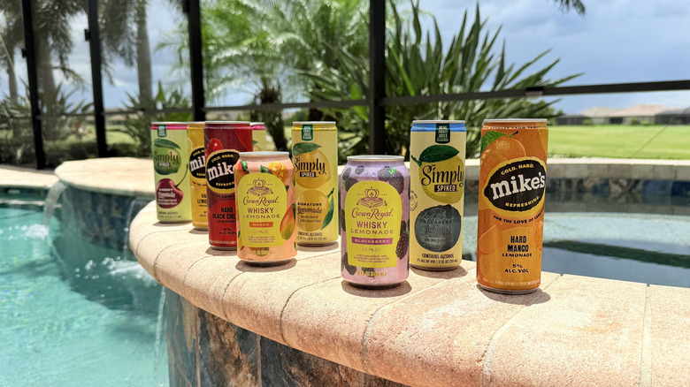 Cans of boozy lemonades by the pool outside
