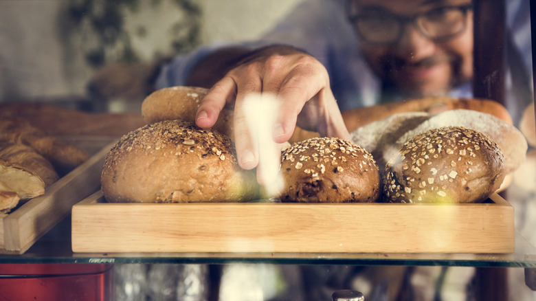 man grabbing bread with bare hands