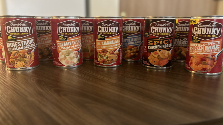 Campbell's soup cans aligned on a brown wooden table