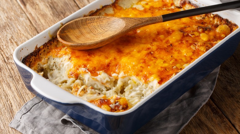 chicken casserole in baking dish with wooden spoon on table