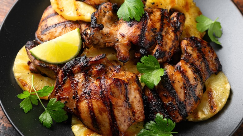 chicken and pineapple on a black plate