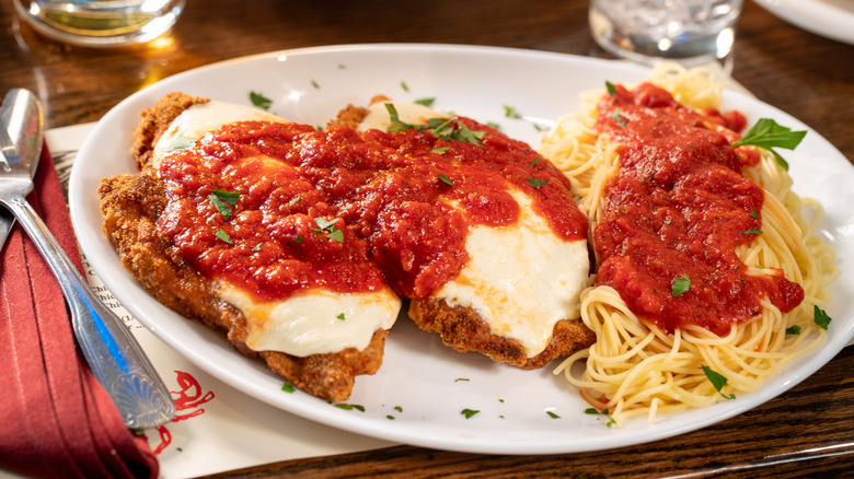 parmesan chicken with noodles on white plate