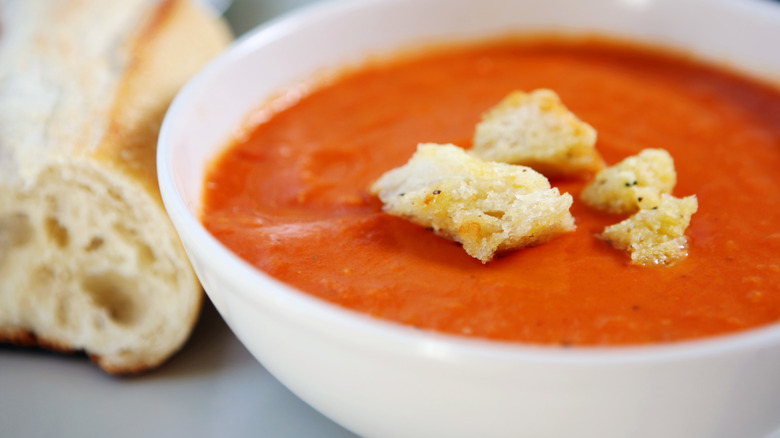 Tomato soup in bowl topped with bread