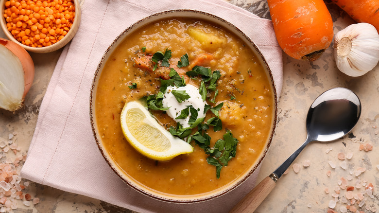 Aerial shot of bowl of lentil soup with lentils, onion, garlic, and carrots