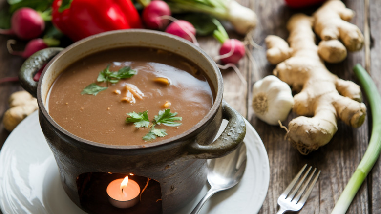 Bagna cauda with a candle for heat and vegetables in the background