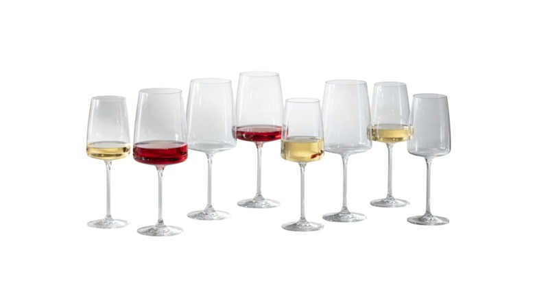 Several wine glasses, some containing red or white wine, on a white background.