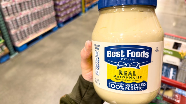 Hand holding large jar of Best Foods Real Mayonnaise in store