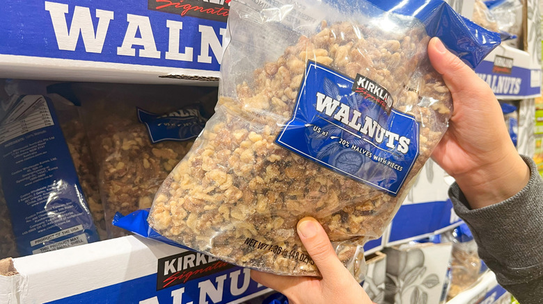Customer grabs bulk bag of Kirkland Signature Walnuts off store shelf