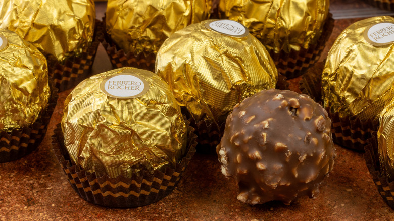 Many Ferrero Rocher chocolates together with one unwrapped