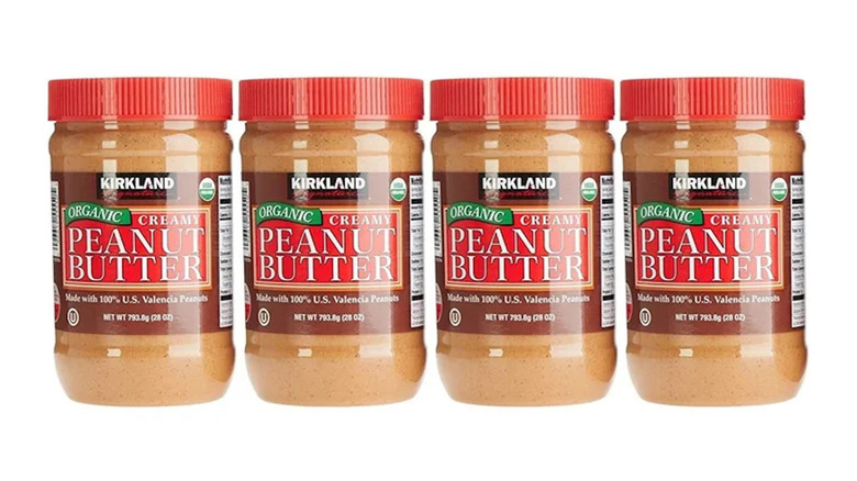 Four jars of Kirkland Signature Organic Peanut Butter in a row