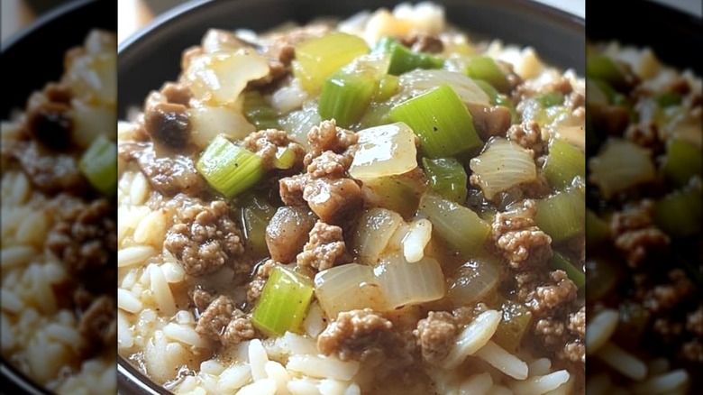 A bowl of rice, vegetables, and ground beef in a black bowl.