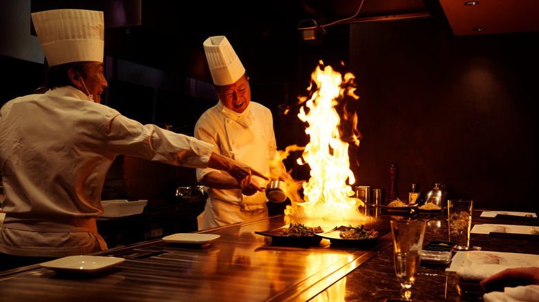 Teppanyaki chefs at work, with large flame on grill
