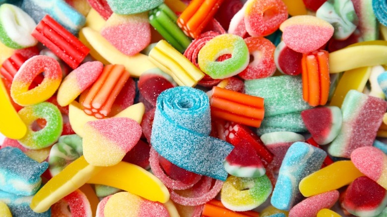 assorted candies including sour strips, gummy rings, and colorful licorice pieces