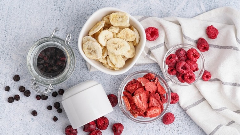 top view of bowls and jars filled with freeze-dried bananas, strawberries, and blueberries