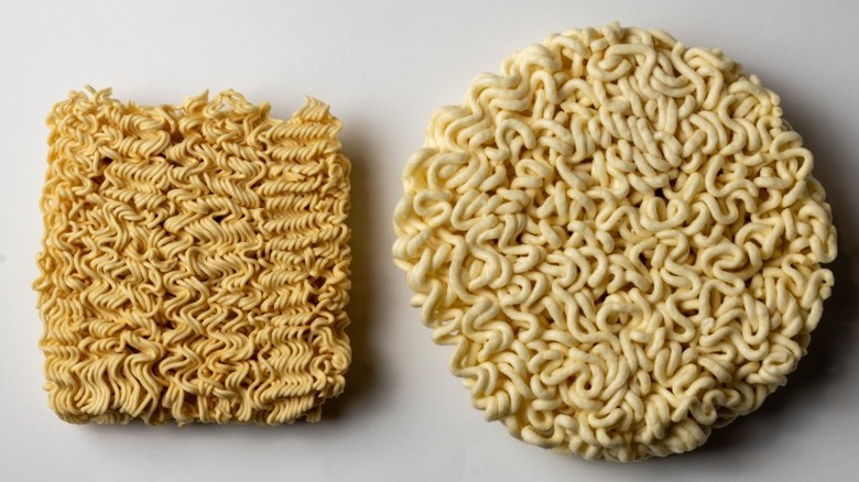 a square block of dry instant ramen noodles and a circular block side by side on a white background