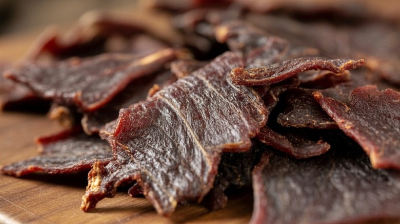 small strips of beef jerky in pile on a wooden table