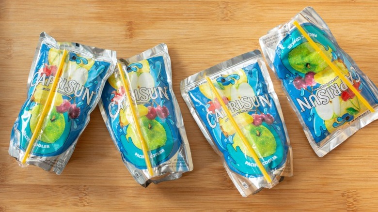 four pacific cooler flavored Capri Sun pouches on a wooden table