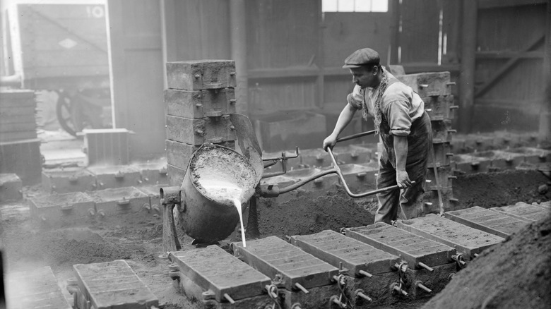 Man pouring molten metal into mold