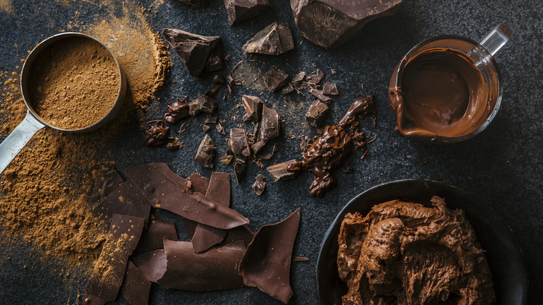 Overhead view of chocolate chunks, chocolate frosting and cocoa