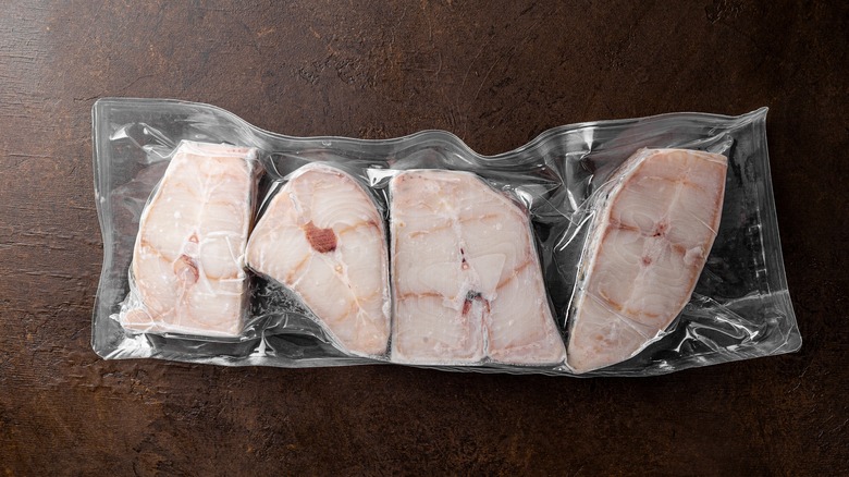 Four frozen catfish steaks in vacuum-sealed packaging