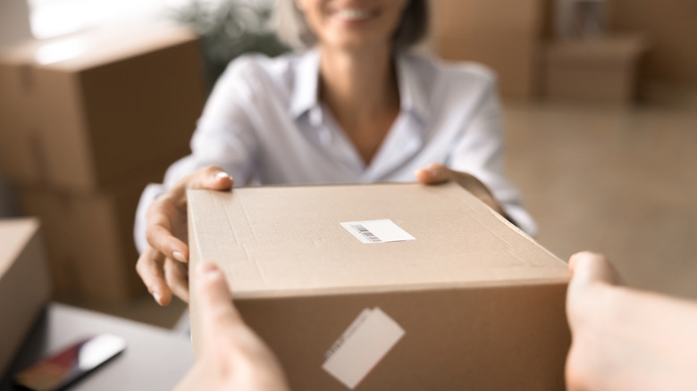 Women handing a parcel for shipment to someone else