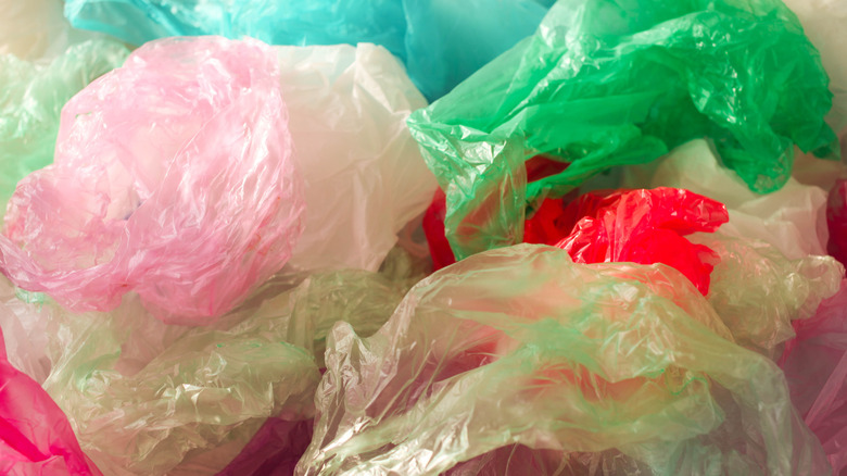 A close-up of a pile of plastic grocery bags in different colors