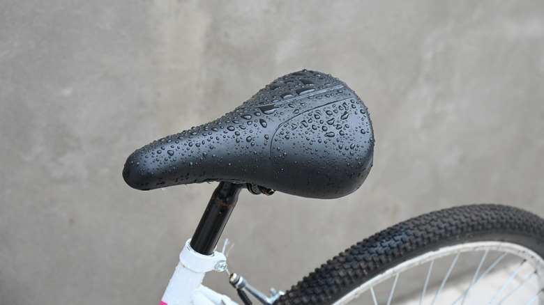 Close-up of a bicycle with its seat covered in rainwater