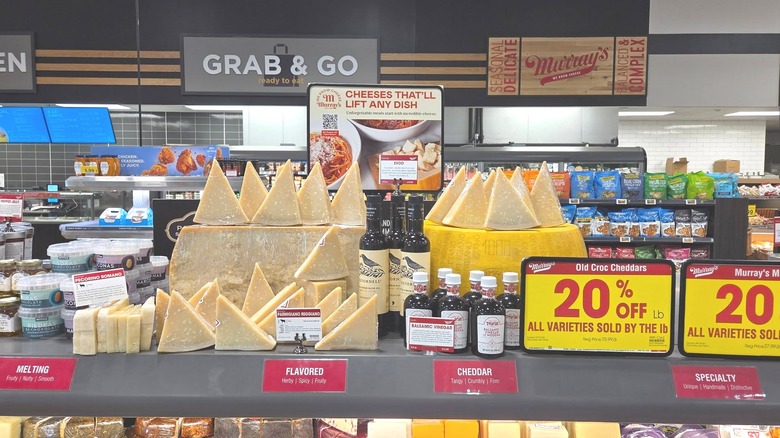 Stacked cheeses and charcuterie sides within a Kroger groocery store.