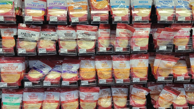 Multiple rows of Meijer shredded cheese inside a grocery store.