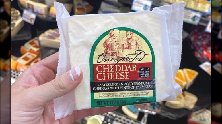 Someone holding Trader Joe's-branded cheese.