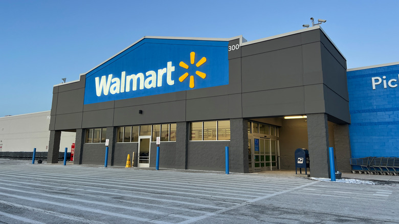 Empty parking lot in front of a Walmart with a clear blue sky in the background