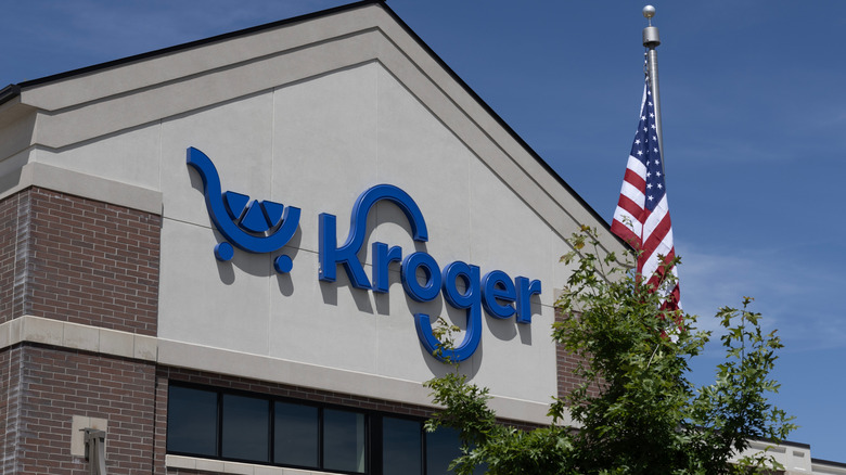 A brick Kroger supermarket with an American flag on a pole in front of the store