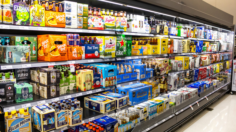 Bottles and cans of beer stocked on grocery store shelves