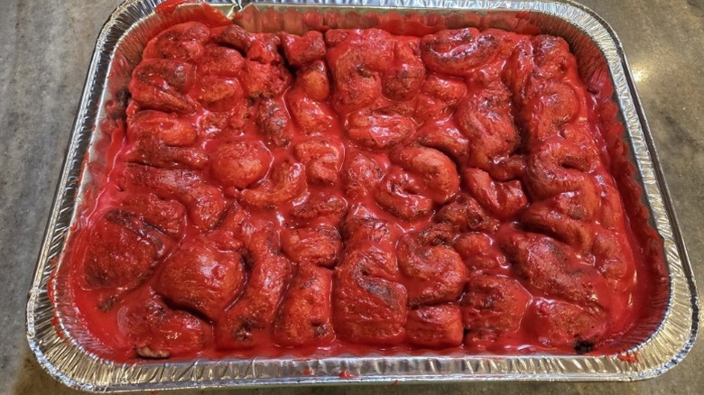 foil pan of deconstructed cinnamon rolls with red frosting