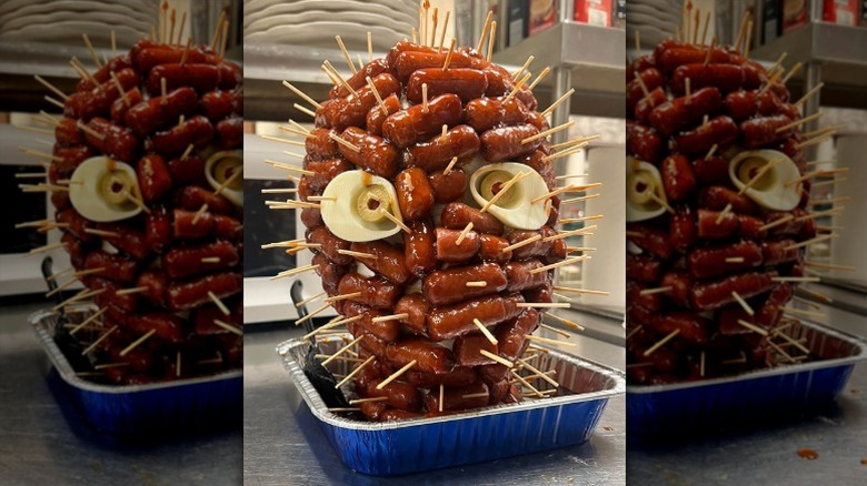 head shape covered with cocktail franks decorated with boiled egg whites and green olives