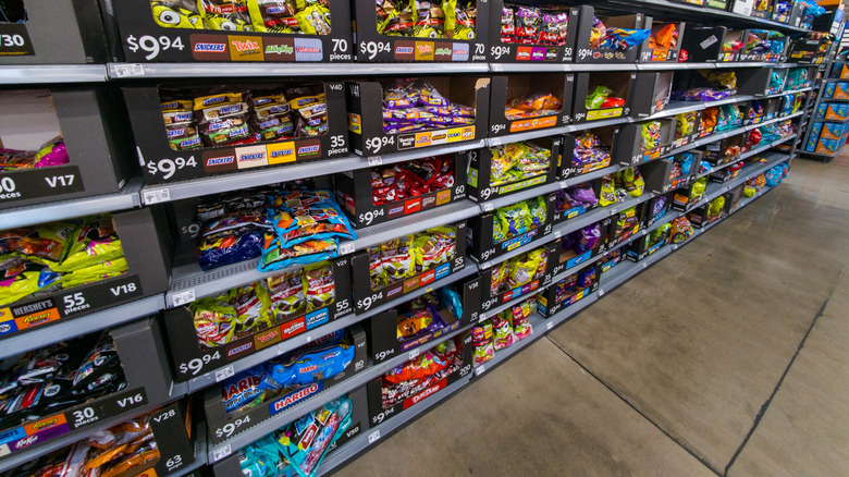 An aisle of bulk Halloween candy on grocery store shelves.