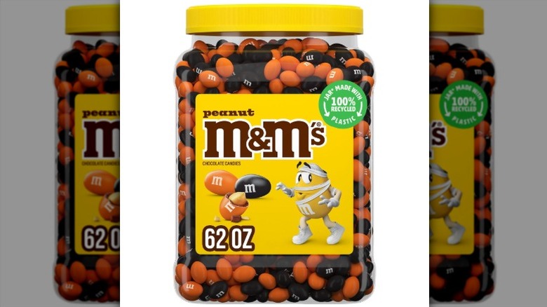 A plastic jar of M&M'S Peanut Milk Chocolate Halloween Candies on a white background.