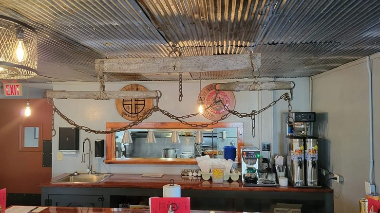 Counter inside Amazin' Blaze Bar-B-Que restaurant with front counter window to the kitchen, coffee makers, and restaurant supplies