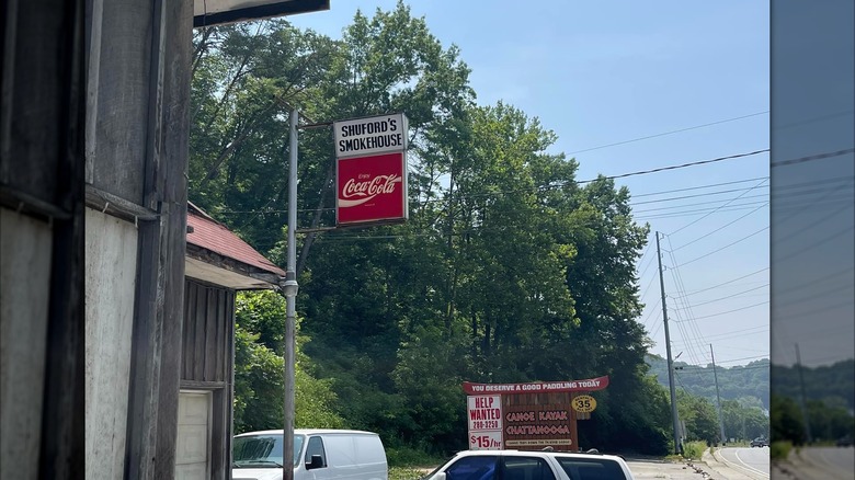 Exterior of Shuford's Smokehouse with the sign and cars parked outside.