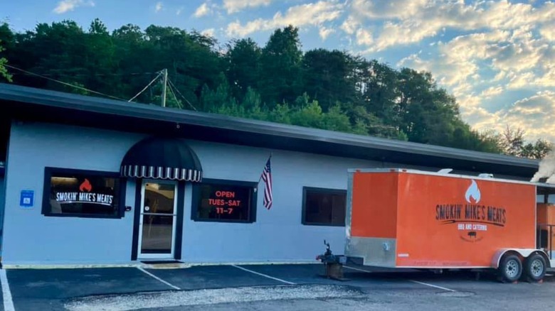 Exterior of Smokin' Mike's Meats with a food trailer parked outside.