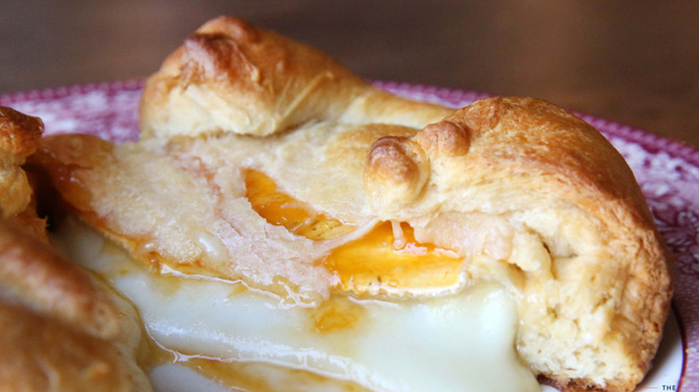 Brie en croute with apricot jam on a plate