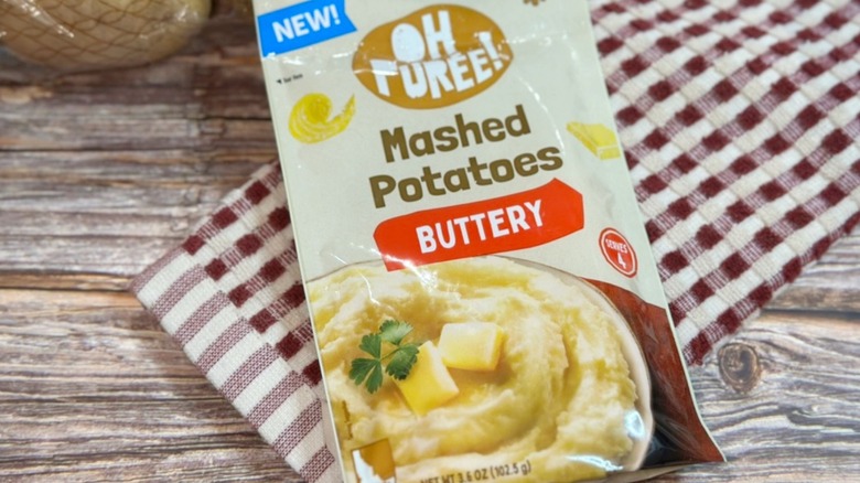 Oh Puree! Buttery Mashed Potatoes package on wooden surface with red checkered towel